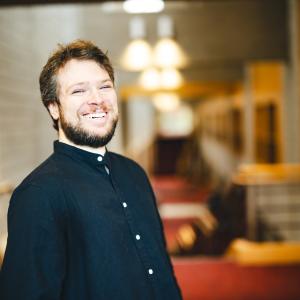 Joshua Aguiar standign for his portrait in the Zoellner Arts Center atrium.