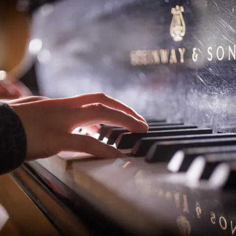 Student playing the piano. 