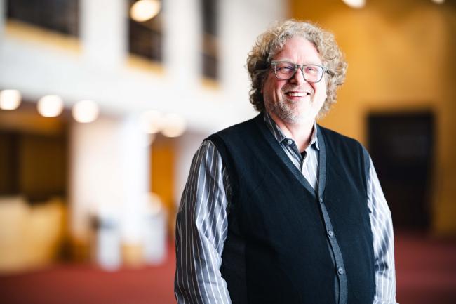 Darin Lewis standing for his portrait in the Zoellner Arts Center.