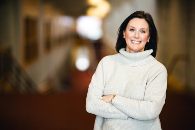 Lisa Basara standing with her arms crossed for her portrait in Zoellner Arts Center.