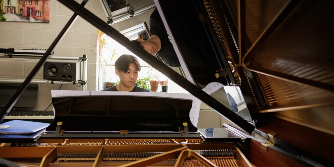 Student playing the piano in a classroom.